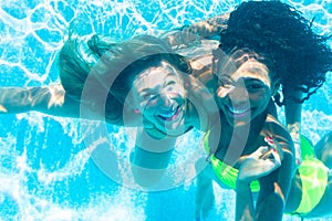 Friends diving underwater in swimming pool