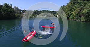 Friends doing backflip from canoe into river