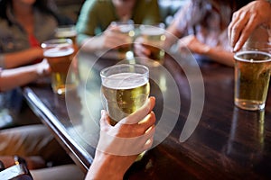 Friends drinking beer at bar or pub
