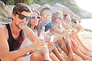 Friends drinking beer on beach