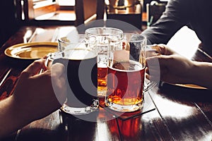 Friends drinking beer from mugs in brewery pub