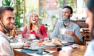 Friends drinking cappuccino at coffee house - Young people having fun together at restaurant - New normal lifestyle concept