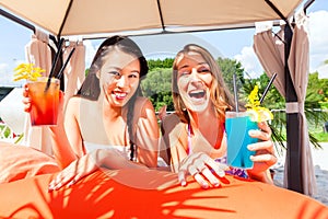 Friends drinking cocktails in beach bar