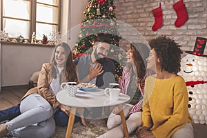 Friends drinking coffee at home on Christmas morning