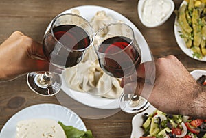 Friends drinking wine over table served with traditional Georgian dishes