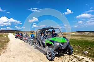 Friends driving off-road with quad bike or ATV and UTV vehicles