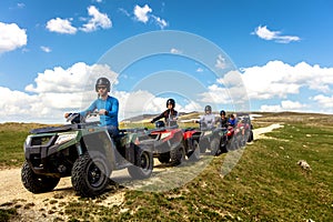 Friends driving off-road with quad bike or ATV and UTV vehicles