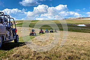 Friends driving off-road with quad bike or ATV and UTV vehicles