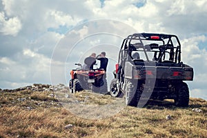 Friends driving off-road with quad bike or ATV and UTV vehicles photo