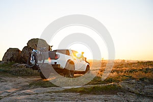 Friends Driving Pickup Offroad Truck in the Mountains with Bikes in the Body at Sunset. Adventure and Travel Concept.