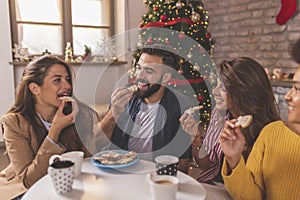 Friends eating Christmas cookies and drinking coffee