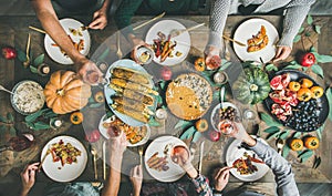 Friends eating and feasting at Thanksgiving Day with vegetarian meals