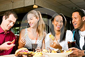 Friends eating hamburger and drinking soda