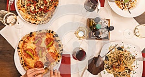 friends eating pasta, pizza and wine - people having meal in restaurant - Focus on center table - Summer lifestyle, food and