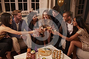 Friends Eating Snacks As They Celebrate At Party Together