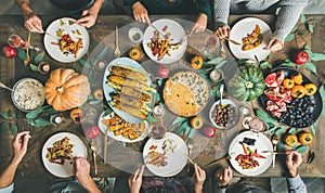 Friends eating at Thanksgiving Day table with vegetarian snacks