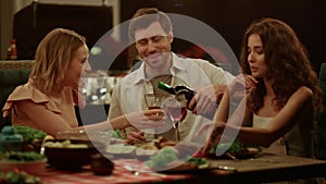 Friends enjoying outdoor dinner on backyard. Man flirting with women