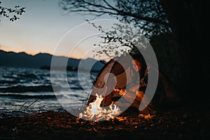 Friends enjoying togetherness at a lakeside campfire on a camping trip