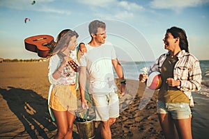 Friends enjoying a walk on the beach on a sunny day and having fun