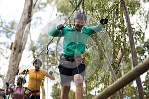 Friends enjoying zip line adventure in park