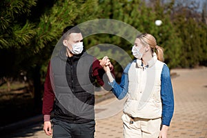 Friends in face masks walk in the park for fear of becoming infected with coronavirus