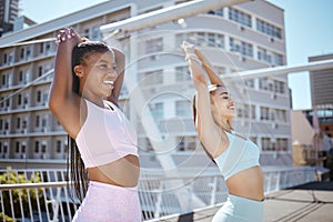 Friends, fitness and training together in the city on summer day. Workout, stretching and two young women exercising