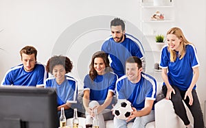 Friends or football fans watching soccer at home