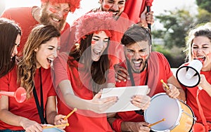 Friends football fans watching soccer match event on mobile digital tablet - Young crazy people having fun supporting club