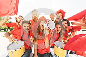 Friends football fans watching soccer match event at stadium - Young people having fun supporting club on sport world championship