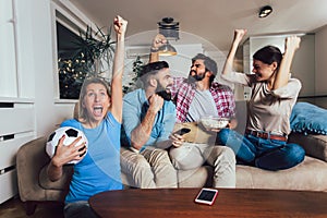 Friends or football fans watching soccer on tv and celebrating victory at home.Friendship, sports and entertainment concept