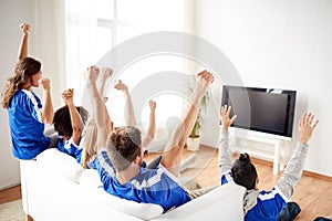 Friends or football fans watching tv at home