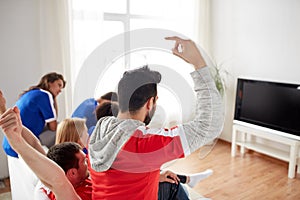 Friends or football fans watching tv at home