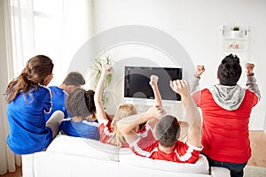 Friends or football fans watching tv at home