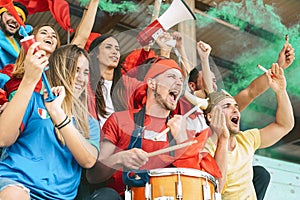 Friends football supporter fans watching soccer match event at stadium - Young people having fun supporting club