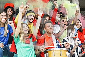 Friends football supporter fans watching soccer match event at stadium - Young people having fun supporting club