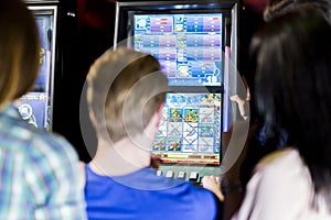 Friends gambling in a casino playing slot and various machines