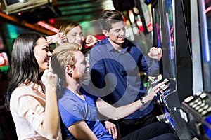 Friends gambling in a casino playing slot and various machines