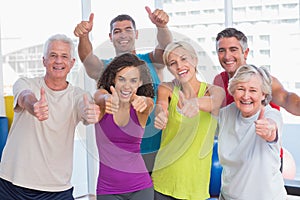 Friends gesturing thumbs up in fitness club