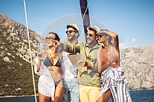 Friends with glasses of champagne on yacht. Vacation, travel, sea, friendship and people concept