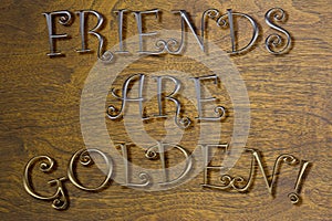 FRIENDS ARE GOLDEN wall art against a wood background in fun, colorful text