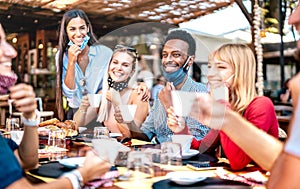 Friends group drinking cappuccino at coffee bar - People having fun together at cafeteria with face masks - New normal concept