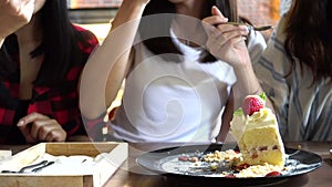 Friends group of female enjoy eating cake and having a conversation at cafe and restaurant