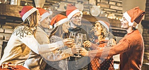 Friends group with santa hats celebrating Christmas with champagne wine toast at home dinner - Winter holidays concept