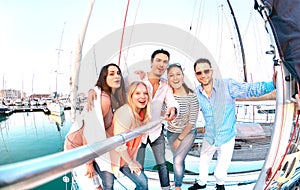 Friends group taking selfie pic with stick on luxury sailing boat party trip - Friendship concept with young millenial people