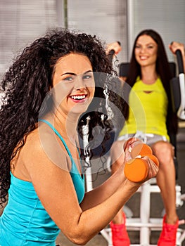 Friends in gym workout with barbells. Fitness training women .