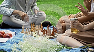 Friends had a picnic and started playing chess in nature in the summer