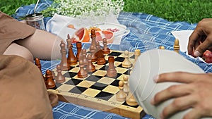 Friends had a picnic and started playing chess in nature in the summer