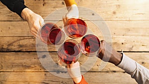 Friends hands toasting red wine glass and having fun cheering with winetasting - Young people enjoying time together at a wine bar