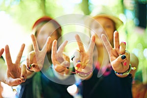 Friends, hands and women with peace sign outdoor at music festival, celebration or event. Closeup, girls and v gesture