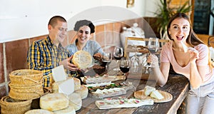 Friends and happy tasting with healthy cheese and wine on table. Smile, diversity and young group of people in